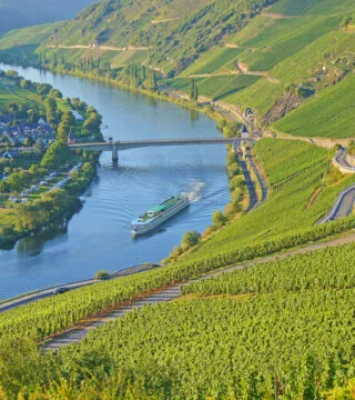 River cruise ship sailing down river in Europe - Cadillac Travel
