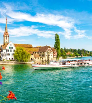 River cruise ship sailing past historic town - Cadillac Travel