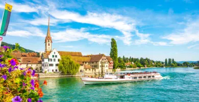 River cruise ship sailing past historic town - Cadillac Travel