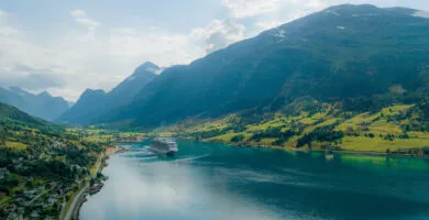 Large cruise ship sailing between fjords - Cadillac Travel