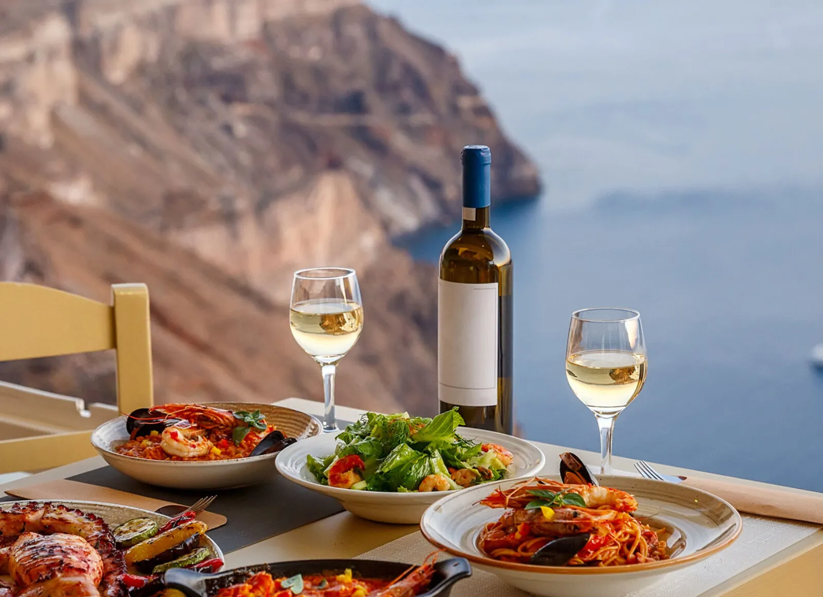 Enjoying food at a cliff side restaurant - Cadillac Travel