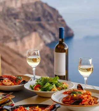 Enjoying food at a cliff side restaurant - Cadillac Travel