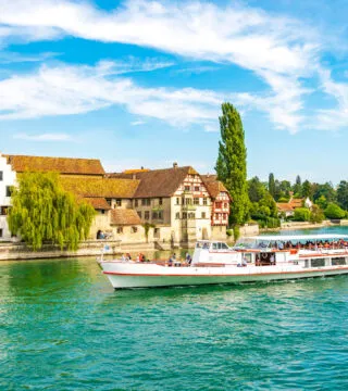 European river cruise with historic town next to river - Cadillac Travel
