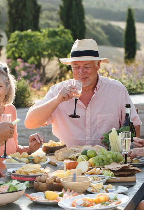 Older tourists enjoying a meal in a vineyard - Cadillac Travel