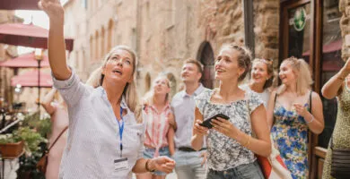 Tour guide showing people around historic city - Cadillac Travel