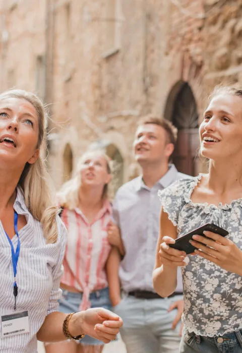 Tour guide showing people around historic city - Cadillac Travel