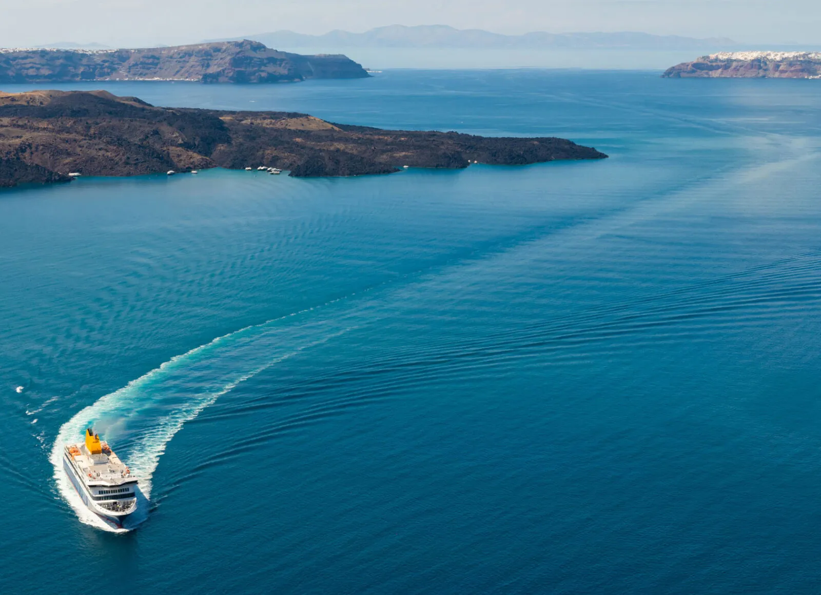 Cruise ship sailing in blue water in Greece - Cadillac Travel