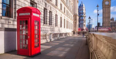 Red phone box in London with Big Ben in the background - Cadillac Travel