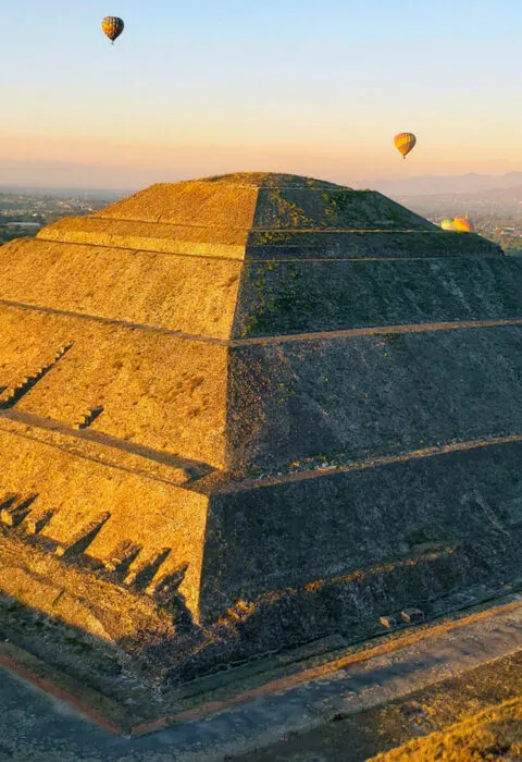 mexican temple during sunset with hot air balloons in the background - Cadillac Travel