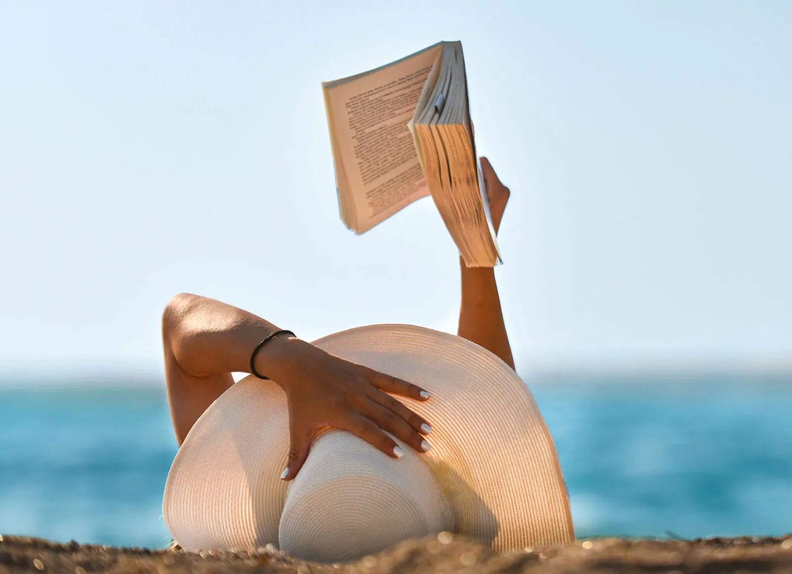 reading on beach - Cadillac Travel