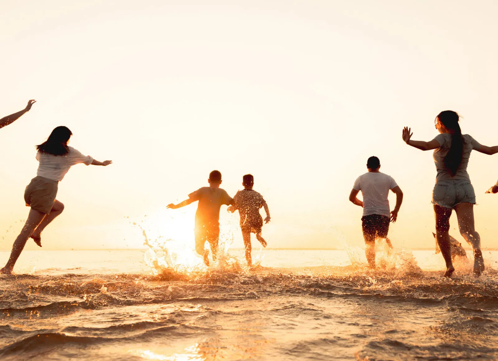 group of travellers running into the sea - Cadillac Travel