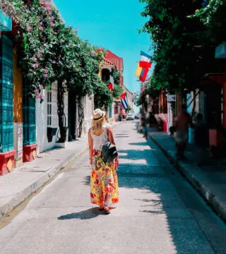 woman walking down a road enjoying the colourful buildings - Cadillac Travel