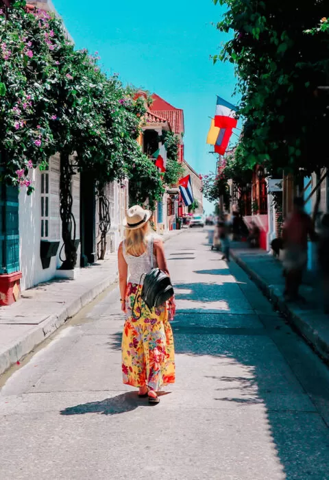 woman walking down a road enjoying the colourful buildings - Cadillac Travel