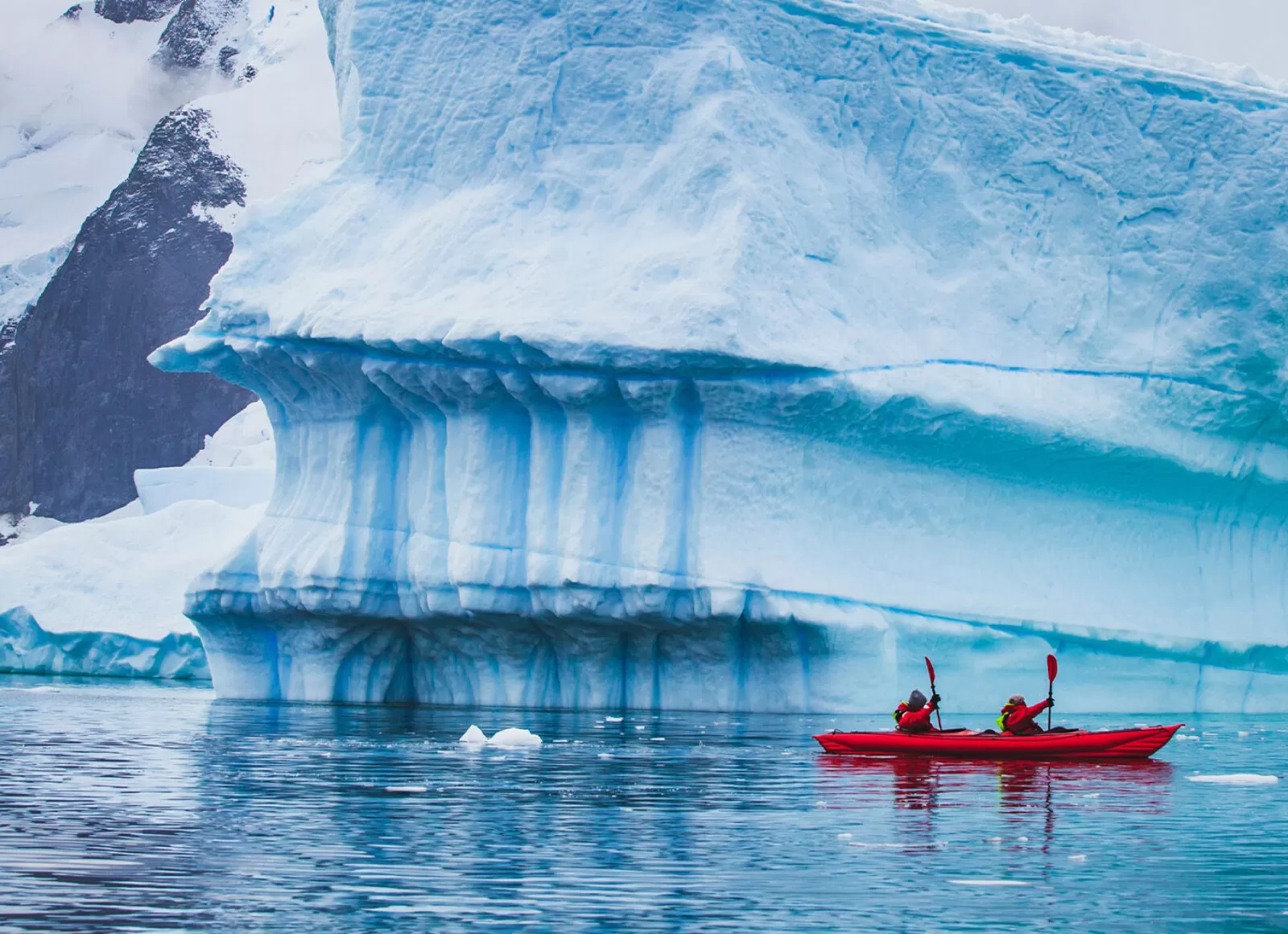 Kayakers on an Arctic adventure, Kayaking past a giant iceberg - Cadillac Travel,Detroit, MI