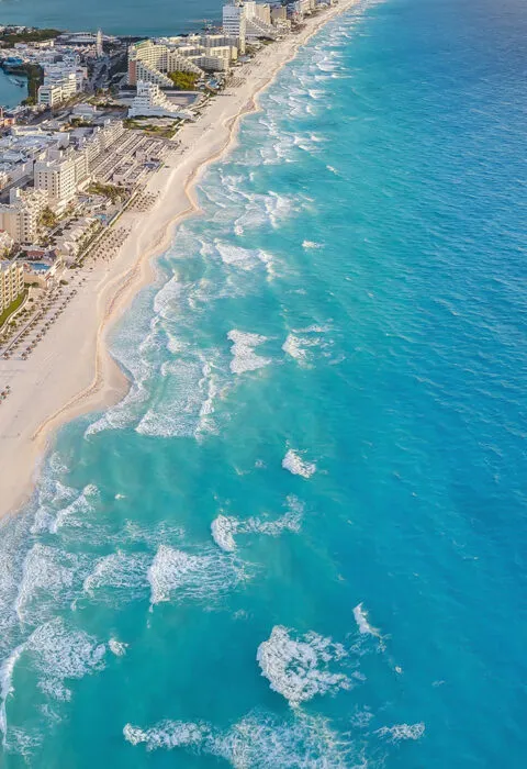 mexico beach line with blue waters and boat sailing - Cadillac Travel, Detroit, MI