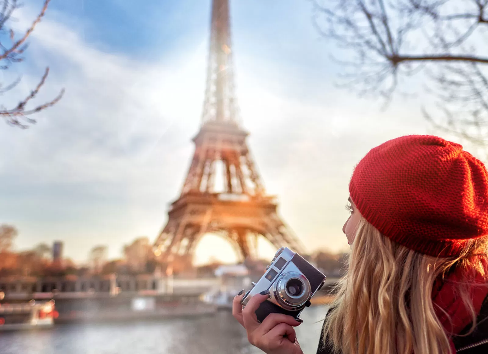 Woman with camera in her hand looking at the Eiffel Tower - Cadillac Travel, Detroit, MI