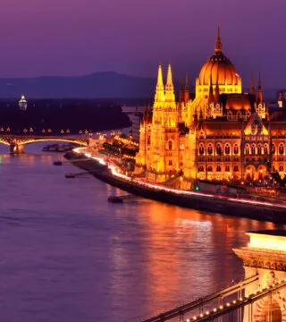 River cruise at night with historic building in the back ground - Cadillac Travel, Detroit, MI