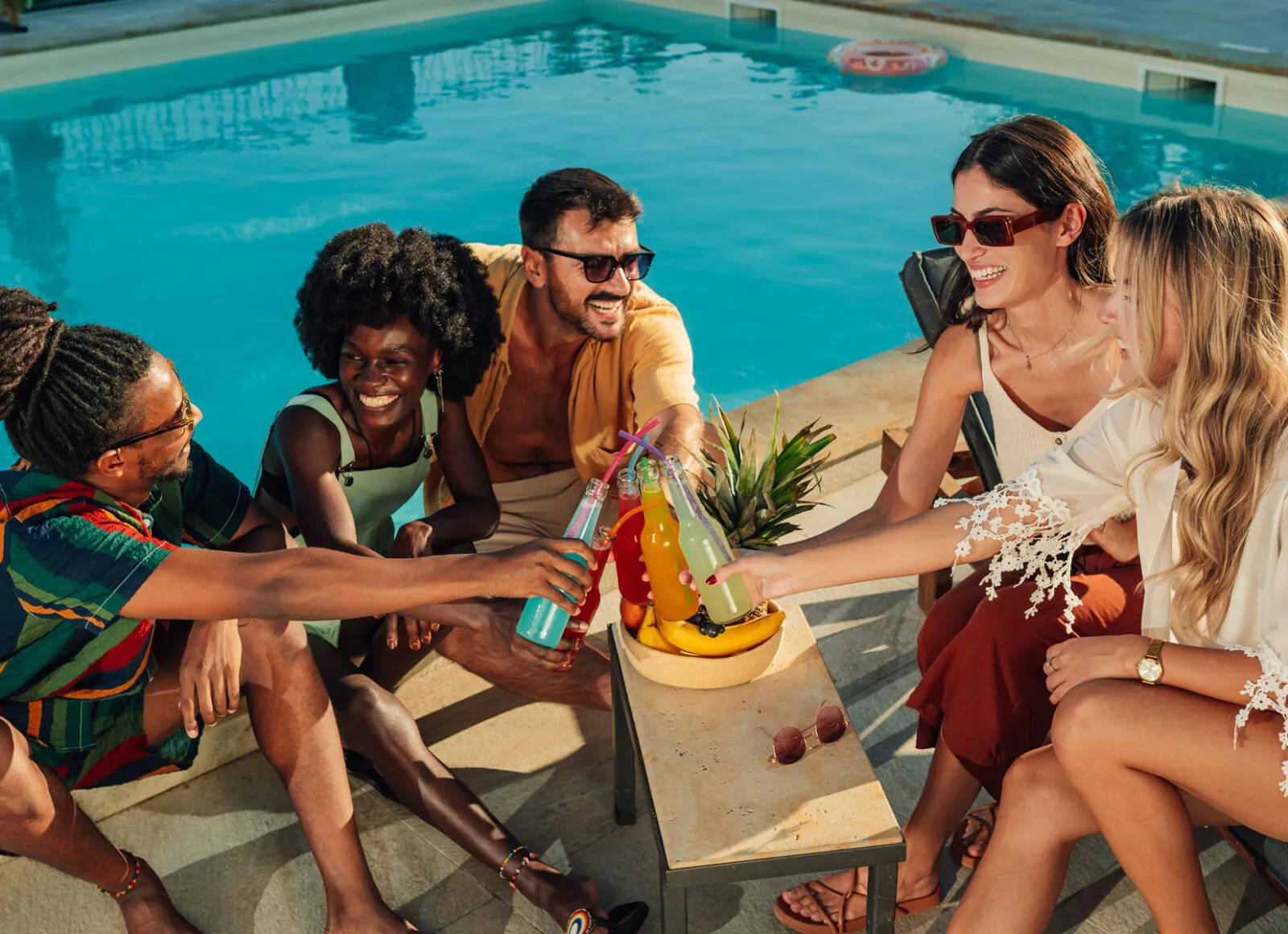 Friends relaxing and drinking at pool - Cadillac Travel